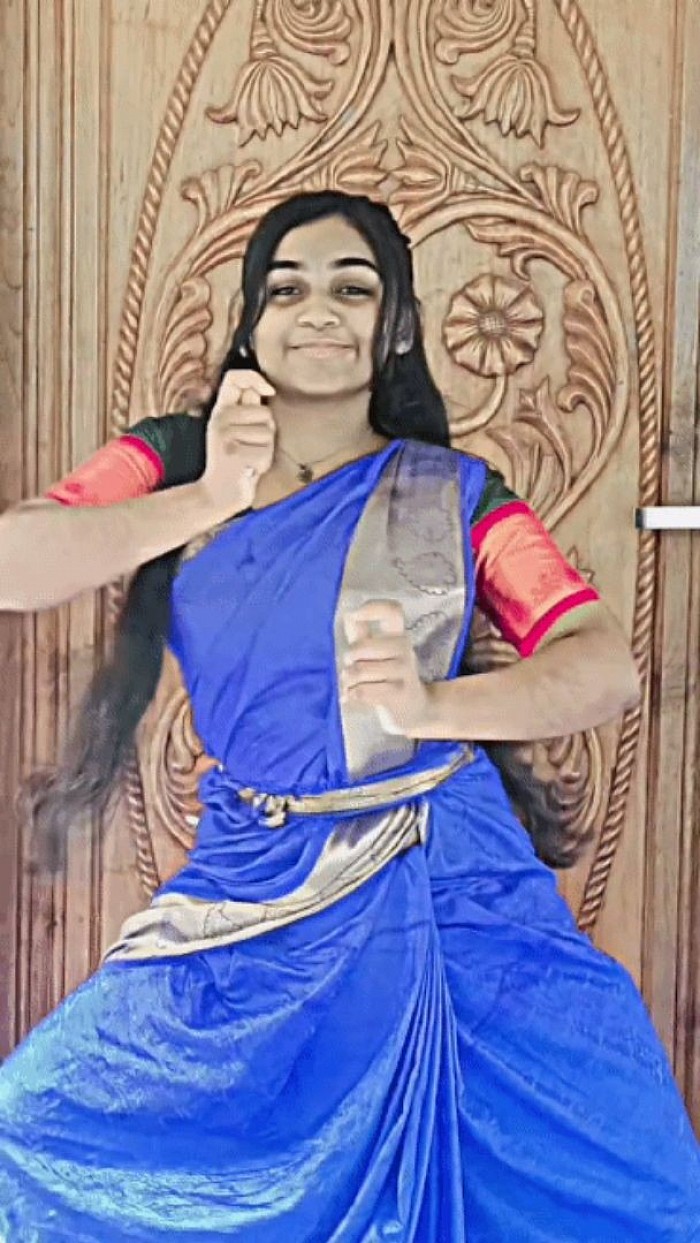 An asian female dancer is dancing passionate classical dance. She is in an attractive pose.